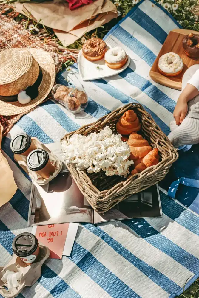 Sunday Crate breakfast: croissants, coffee and flowers on a picnic blanket